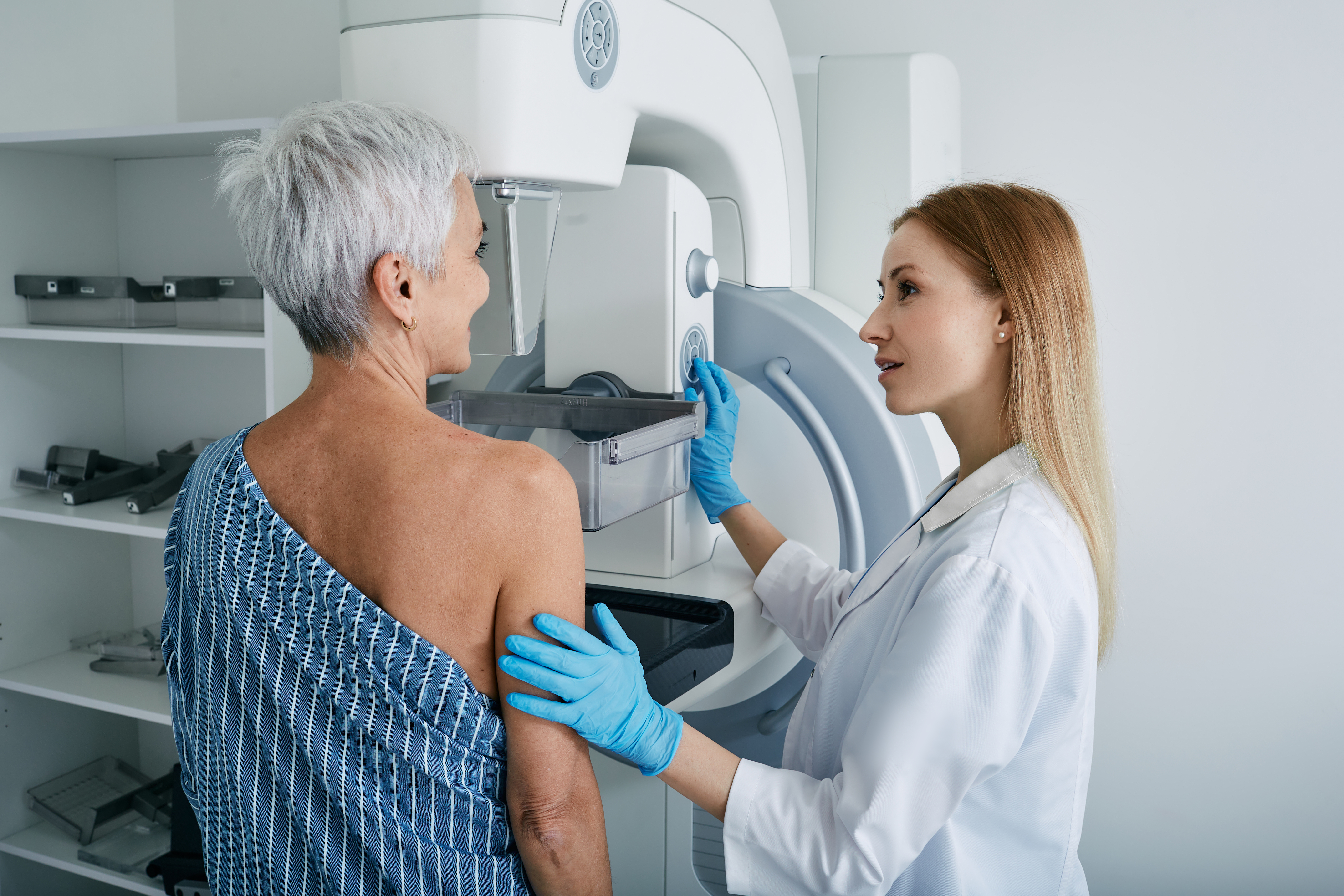 Woman getting mammogram while health care worker assists